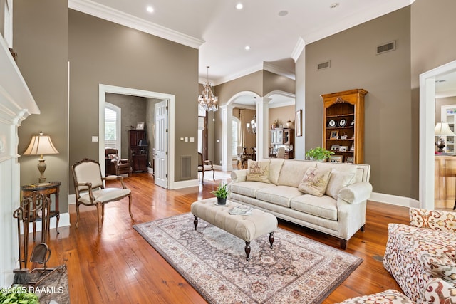 2822 Teal Dr, New Iberia, LA 70560 - living area with decorative columns, arched walkways, ornamental molding, light wood-style floors, and recessed lighting
