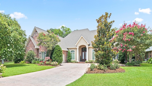 2822 Teal Dr, New Iberia, LA 70560 - view of front facade with concrete driveway, a front yard, a shingled roof, brick siding, and stucco siding