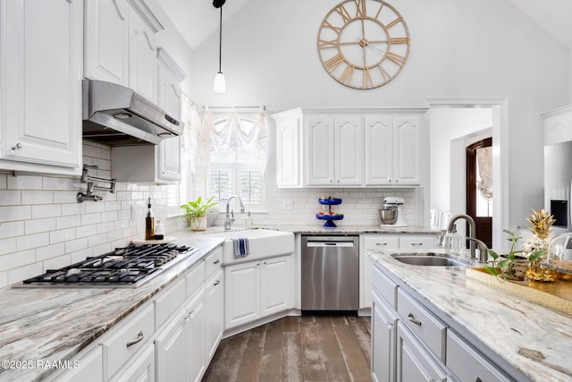 144 Cypress Cv, Youngsville, LA 70592 - kitchen featuring appliances with stainless steel finishes, under cabinet range hood, a sink, white cabinetry, and high vaulted ceiling