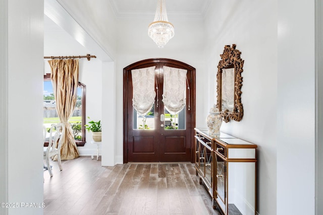 144 Cypress Cv, Youngsville, LA 70592 - foyer entrance featuring a chandelier, light wood-type flooring, ornamental molding, and baseboards