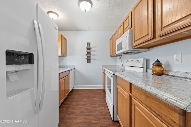 100 Winchester Dr Unit 308, Lafayette, LA 70506 - kitchen with white appliances, dark wood-style floors, baseboards, a textured ceiling, and brown cabinets