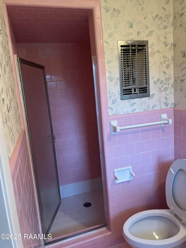 500 Brentwood Blvd, Lafayette, LA 70503 - bathroom featuring wallpapered walls, a wainscoted wall, a shower stall, toilet, and tile walls