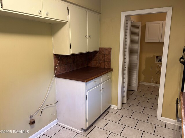 500 Brentwood Blvd, Lafayette, LA 70503 - kitchen with dark countertops, light tile patterned flooring, tasteful backsplash, baseboards, and white cabinetry