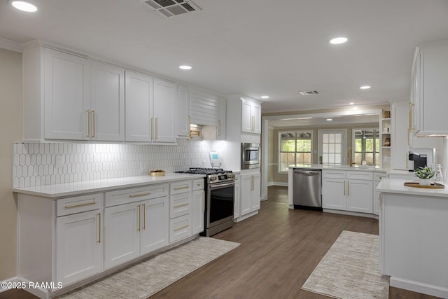 178 Bertrand Rd, Opelousas, LA 70570 - kitchen with appliances with stainless steel finishes, white cabinetry, backsplash, light countertops, and dark wood-style floors