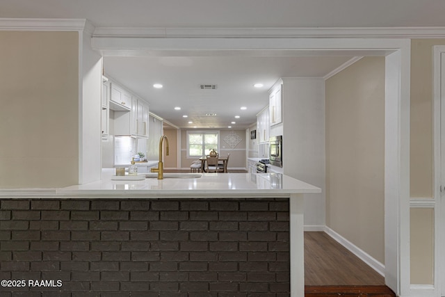 178 Bertrand Rd, Opelousas, LA 70570 - kitchen with white cabinetry, a sink, dark wood-style flooring, recessed lighting, and a peninsula