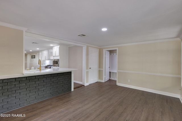 178 Bertrand Rd, Opelousas, LA 70570 - unfurnished living room with dark wood finished floors, crown molding, baseboards, a sink, and recessed lighting