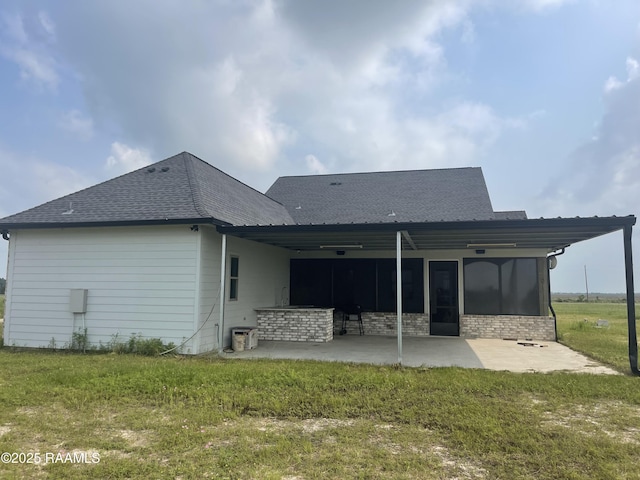5087 Natali Rd, Lake Charles, LA 70607 - back of property featuring a patio, a lawn, a shingled roof, and a sunroom