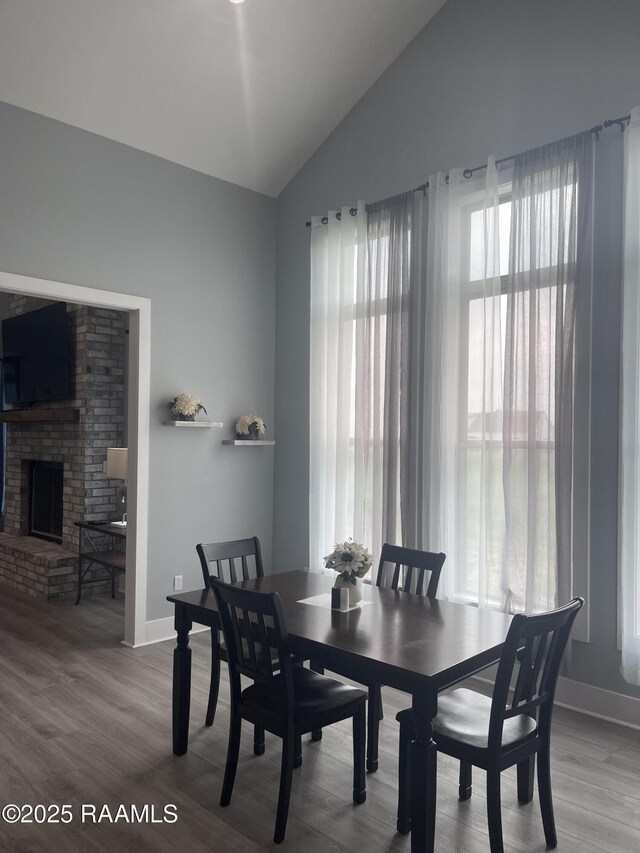 5087 Natali Rd, Lake Charles, LA 70607 - dining space with lofted ceiling, wood finished floors, baseboards, and a brick fireplace