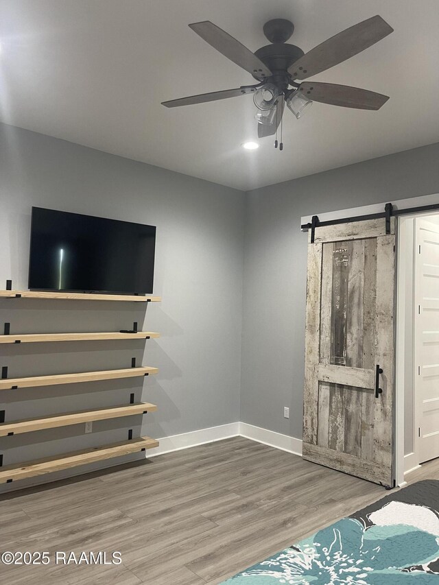 5087 Natali Rd, Lake Charles, LA 70607 - unfurnished living room featuring baseboards, wood finished floors, ceiling fan, and a barn door