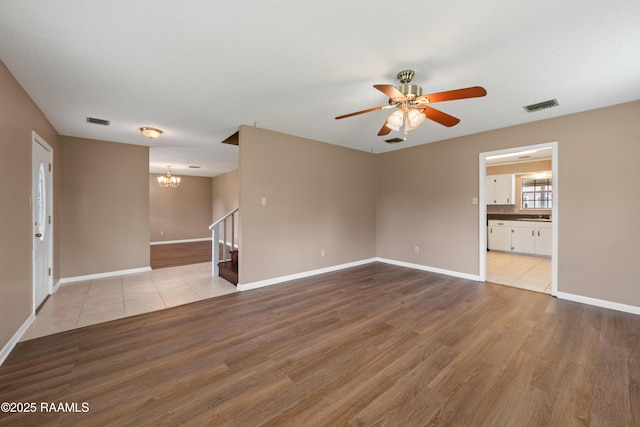 221 Timothy Dr, Lafayette, LA 70503 - spare room with stairs, a chandelier, wood finished floors, and ceiling fan