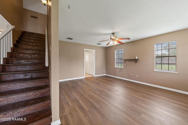 221 Timothy Dr, Lafayette, LA 70503 - staircase with a ceiling fan, wood finished floors, baseboards, and a textured ceiling