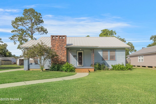 108 Trotter St, New Iberia, LA 70563 - view of front of home featuring a chimney, a front yard, and metal roof