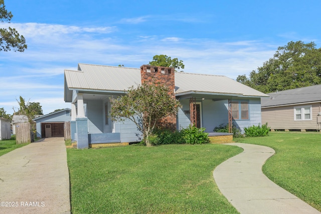 108 Trotter St, New Iberia, LA 70563 - view of front of property with an outdoor structure, a front lawn, a chimney, metal roof, and a porch