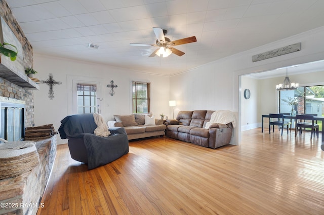 108 Trotter St, New Iberia, LA 70563 - living room featuring a chandelier, crown molding, ceiling fan, wood finished floors, and a stone fireplace