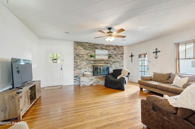 108 Trotter St, New Iberia, LA 70563 - living area featuring crown molding, light wood-style flooring, a ceiling fan, and a fireplace