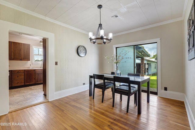 108 Trotter St, New Iberia, LA 70563 - dining area with a chandelier, light wood-type flooring, baseboards, and ornamental molding
