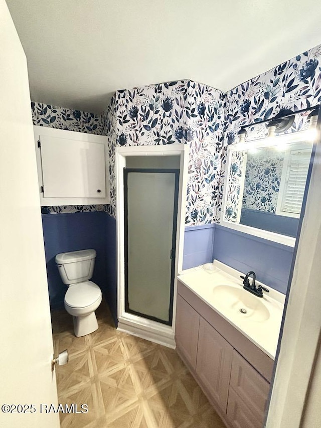 930 N 7th St, Eunice, LA 70535 - bathroom featuring wallpapered walls, toilet, vanity, wainscoting, and a stall shower