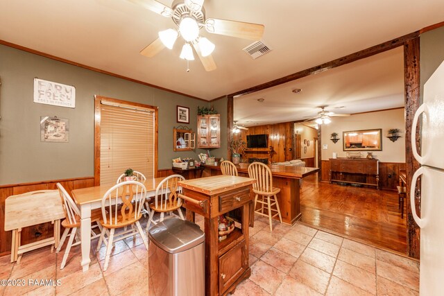 2944 Main Hwy, Breaux Bridge, LA 70517 - dining room with ceiling fan, crown molding, wood walls, and a wainscoted wall