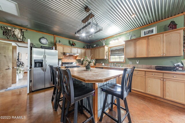 2944 Main Hwy, Breaux Bridge, LA 70517 - kitchen with stainless steel refrigerator with ice dispenser, under cabinet range hood, light brown cabinets, a kitchen island, and crown molding