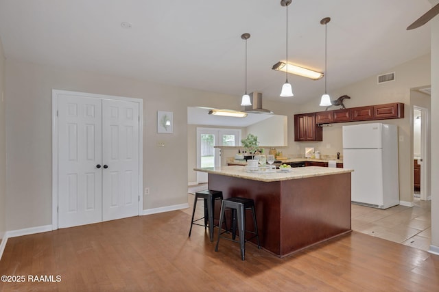 213 Marilyn Dr, Lafayette, LA 70503 - kitchen with freestanding refrigerator, a breakfast bar area, light wood finished floors, decorative light fixtures, and lofted ceiling