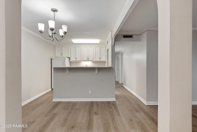 220 Doucet Rd Unit 230D, Lafayette, LA 70506 - kitchen featuring freestanding refrigerator, white cabinets, a chandelier, light wood-style flooring, and ornamental molding