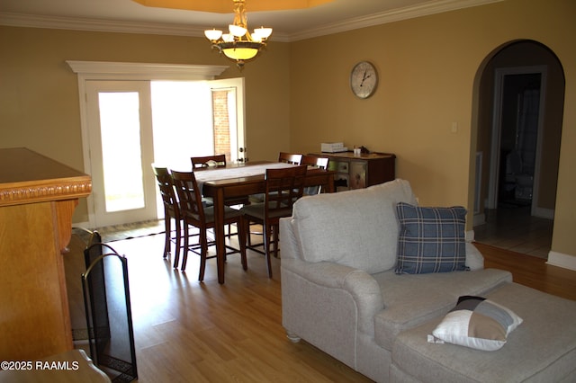 101 David St, Breaux Bridge, LA 70517 - dining room featuring arched walkways, light wood-style flooring, ornamental molding, and a chandelier