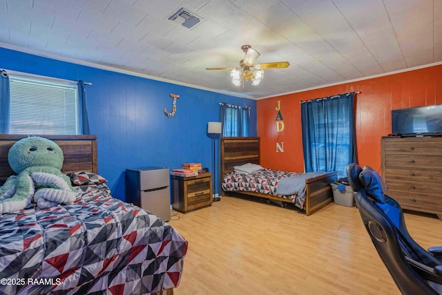 617 Sidney Dr, Breaux Bridge, LA 70517 - bedroom featuring freestanding refrigerator, crown molding, wood finished floors, ceiling fan, and wood walls