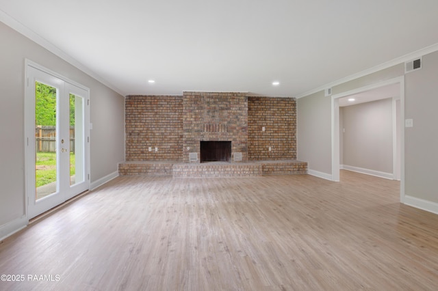 5811 Basile Eunice Hwy, Eunice, LA 70535 - unfurnished living room featuring a fireplace, light wood-style flooring, crown molding, baseboards, and brick wall