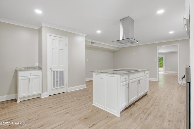 5811 Basile Eunice Hwy, Eunice, LA 70535 - kitchen featuring island exhaust hood, crown molding, light wood-style floors, white cabinetry, and baseboards
