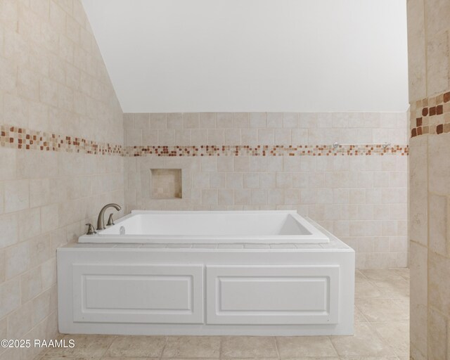 5811 Basile Eunice Hwy, Eunice, LA 70535 - full bath featuring tile walls, vaulted ceiling, a bath, and tile patterned flooring