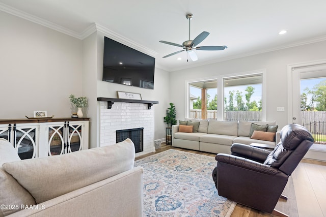 213 Octavia Dr, Scott, LA 70583 - living room featuring light wood finished floors, a ceiling fan, recessed lighting, crown molding, and a brick fireplace