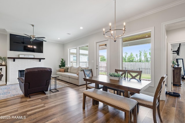213 Octavia Dr, Scott, LA 70583 - dining area with wood finished floors, ornamental molding, ceiling fan, a fireplace, and a chandelier