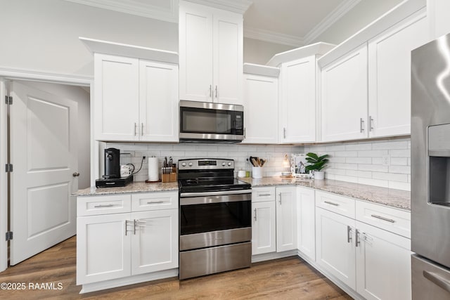 213 Octavia Dr, Scott, LA 70583 - kitchen with stainless steel appliances, ornamental molding, white cabinetry, backsplash, and light wood-style flooring