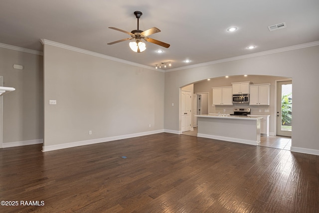 127 Laurel Grove Blvd, Youngsville, LA 70592 - unfurnished living room featuring arched walkways, a ceiling fan, crown molding, dark wood-type flooring, and baseboards