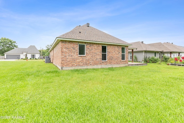 147 Gable Crest Dr, Lafayette, LA 70507 - back of property featuring roof with shingles, brick siding, a lawn, and a garage