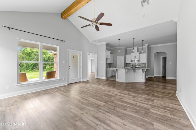147 Gable Crest Dr, Lafayette, LA 70507 - unfurnished living room featuring a ceiling fan, beamed ceiling, high vaulted ceiling, light wood-style flooring, and arched walkways