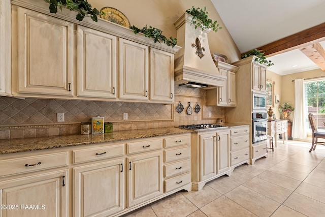 104 Baltimore Ln, Lafayette, LA 70506 - kitchen featuring appliances with stainless steel finishes, tasteful backsplash, light tile patterned floors, custom exhaust hood, and stone countertops
