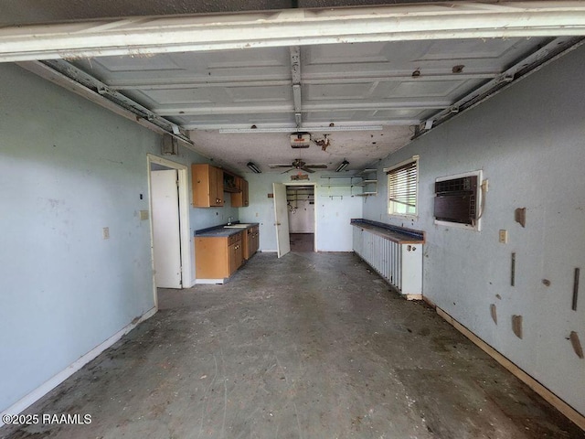 37208 Monceaux Rd, Gueydan, LA 70542 - garage with a garage door opener, a wall mounted AC, baseboards, ceiling fan, and a sink