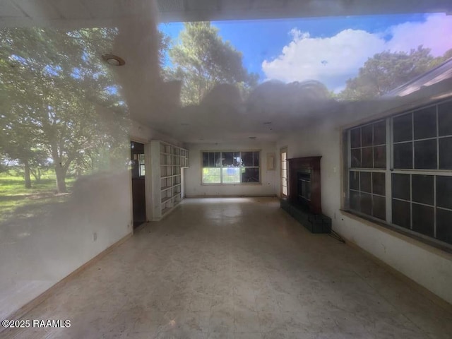 37208 Monceaux Rd, Gueydan, LA 70542 - unfurnished living room with a glass covered fireplace, baseboards, and tile patterned floors