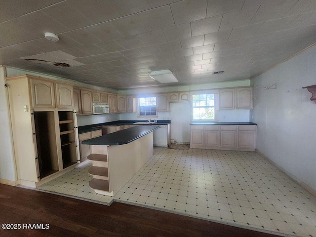37208 Monceaux Rd, Gueydan, LA 70542 - kitchen featuring white microwave, a center island, a sink, open shelves, and dark countertops