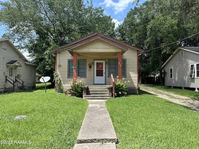 1002 Vidrine St, Opelousas, LA 70570 - bungalow featuring entry steps, a front yard, covered porch, and cooling unit