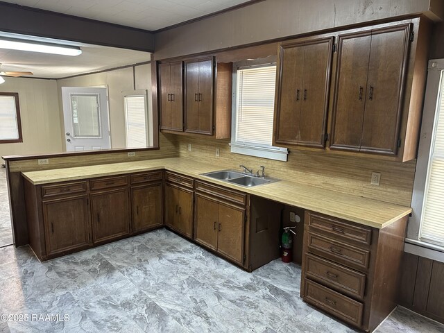 1002 Vidrine St, Opelousas, LA 70570 - kitchen featuring light countertops, a peninsula, a sink, and dark brown cabinetry