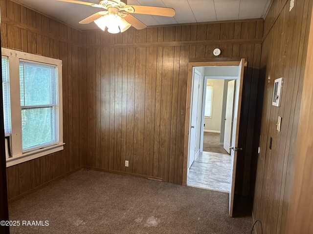 1002 Vidrine St, Opelousas, LA 70570 - carpeted empty room featuring wooden walls, a ceiling fan, and a smoke detector