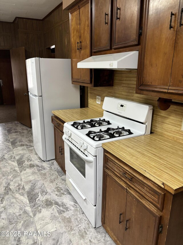 1002 Vidrine St, Opelousas, LA 70570 - kitchen featuring white appliances, under cabinet range hood, and dark brown cabinetry