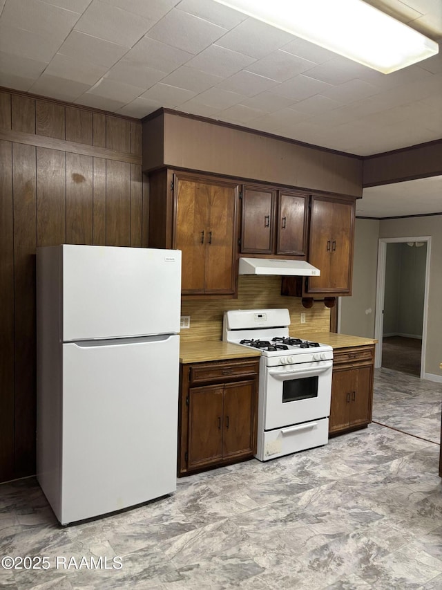 1002 Vidrine St, Opelousas, LA 70570 - kitchen with white appliances, under cabinet range hood, light countertops, and decorative backsplash