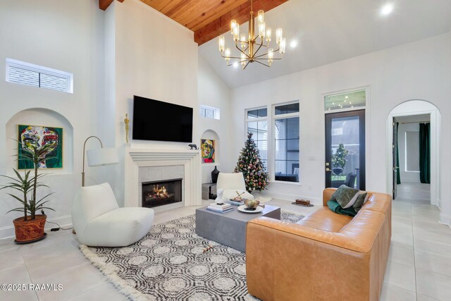 307 Harvest Creek Ln, Lafayette, LA 70508 - tiled living area with high vaulted ceiling, a tile fireplace, a chandelier, arched walkways, and a wood ceiling with exposed beams