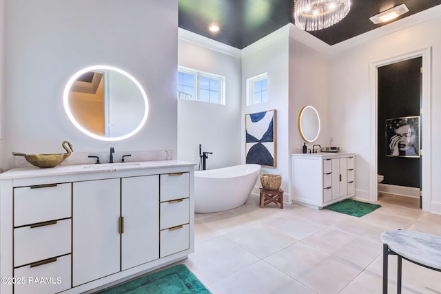 307 Harvest Creek Ln, Lafayette, LA 70508 - bathroom with two vanities, tile patterned floors, and a freestanding tub