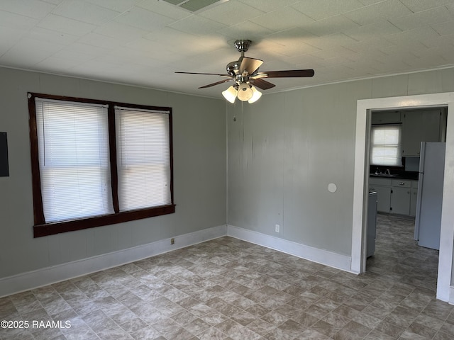 627 S Railroad Ave, Opelousas, LA 70570 - spare room featuring plenty of natural light, baseboards, a ceiling fan, ornamental molding, and a sink