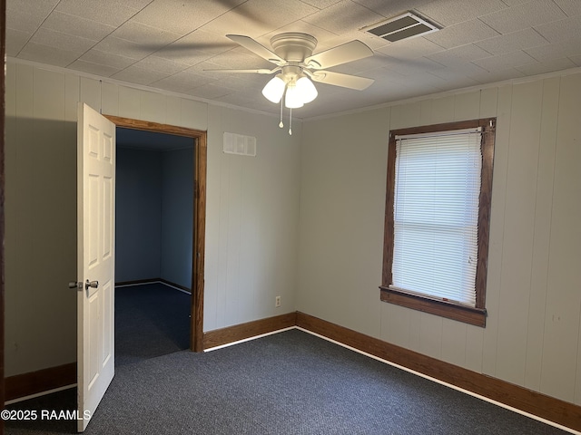 627 S Railroad Ave, Opelousas, LA 70570 - empty room featuring dark carpet, a ceiling fan, baseboards, crown molding, and wood walls