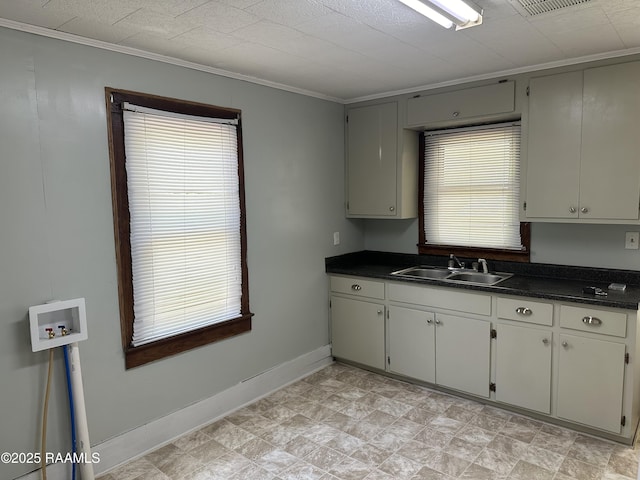 627 S Railroad Ave, Opelousas, LA 70570 - kitchen with a sink, dark countertops, baseboards, and ornamental molding